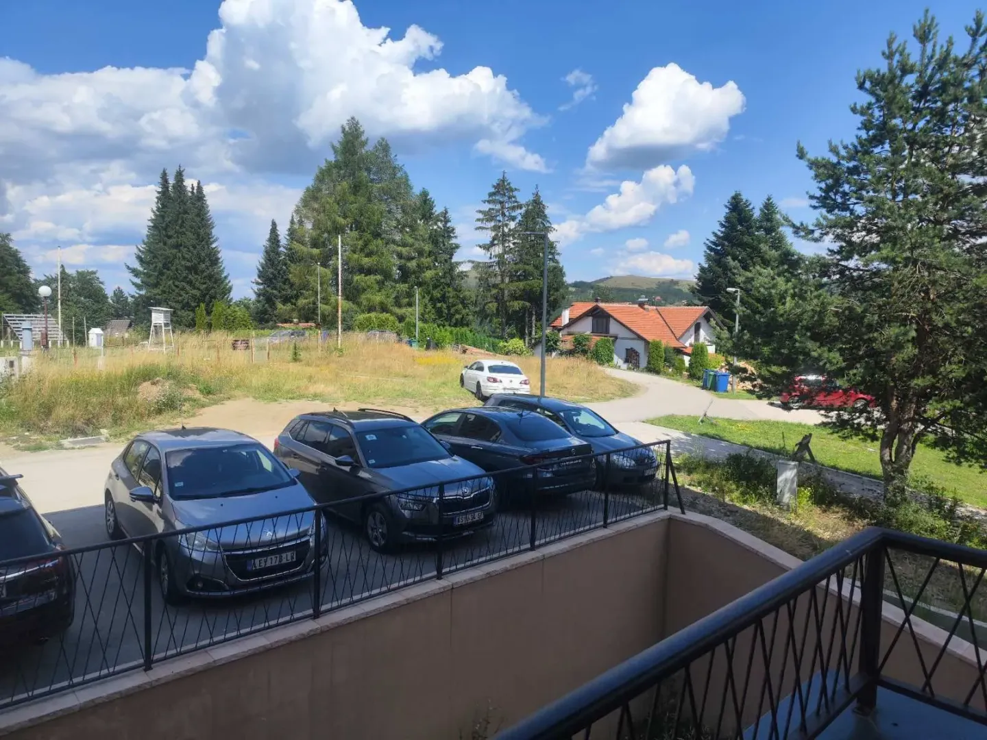 Pogled sa terase na parking i okolno zelenilo.