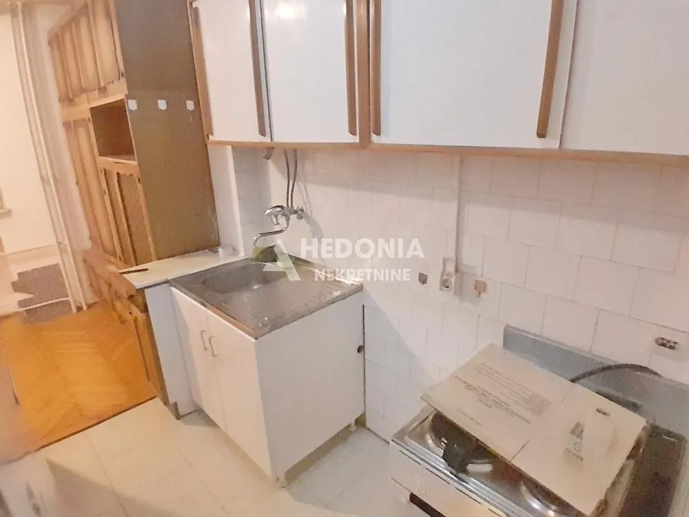 Small kitchen with a sink, cabinetry, and a stove.