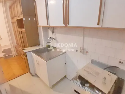 Small kitchen with a sink, cabinetry, and a stove. - image 6