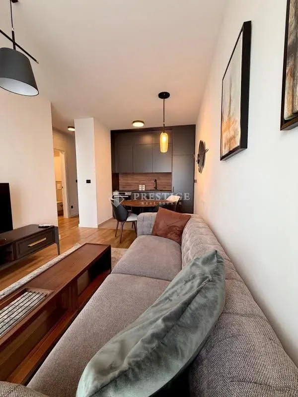 Living room with sofa and view towards the dining area and kitchen.