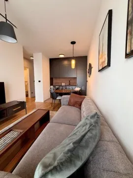 Living room with sofa and view towards the dining area and kitchen. - image 2