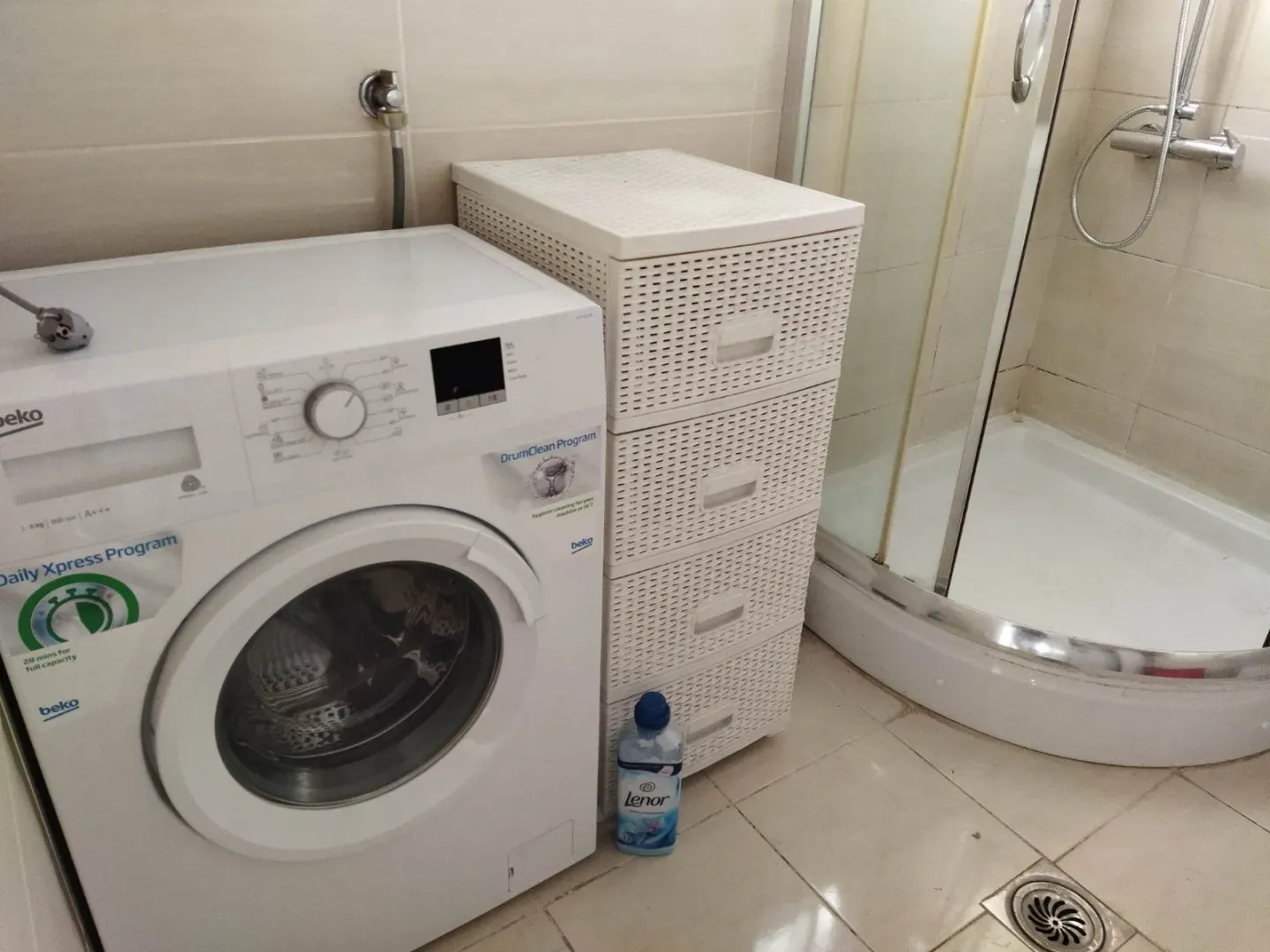 Kupatilo sa veš mašinom i tuš kabinom.