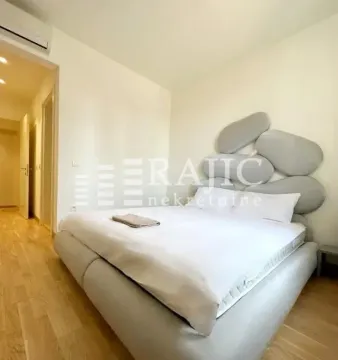 Modern bedroom with a large double bed and unique headboard. - image 2