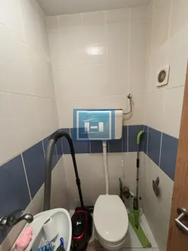 Manje kupatilo sa toaletom, umivaonikom i belo-plavim pločicama. - image 5