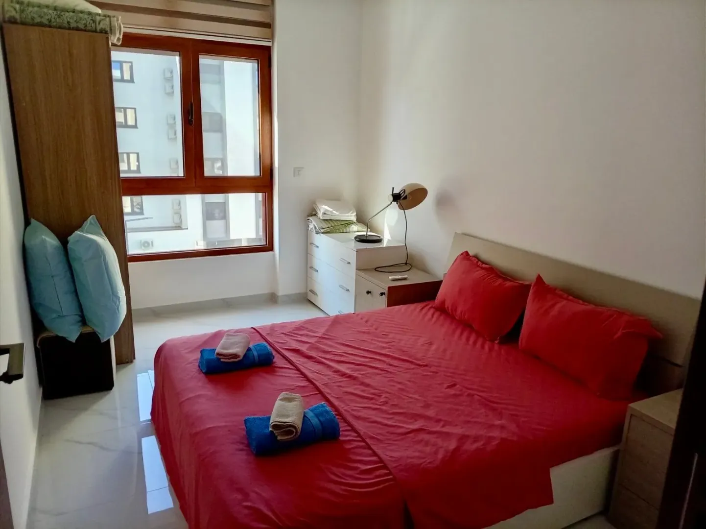 Bright bedroom with a double bed, wardrobe, and a window.