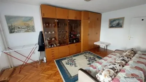 Living room with a large wooden wardrobe, sofa and carpet. - image 4
