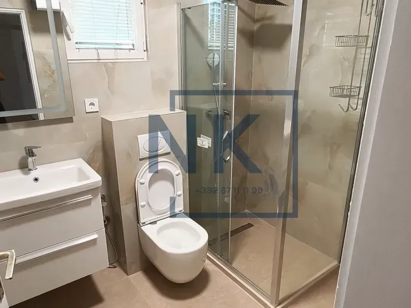 Modern bathroom with a sink, toilet, and walk-in shower.
