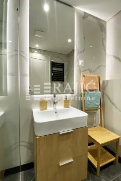 Modernly equipped bathroom with a washbasin, mirror, and wooden elements. - image 9