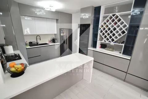 Modern kitchen with an island, built-in appliances, and a built-in wine rack. - image 10