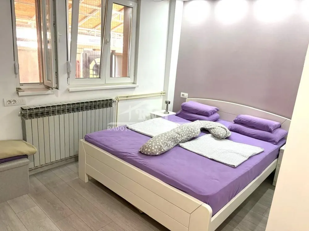 Furnished bedroom with a large double bed and windows.