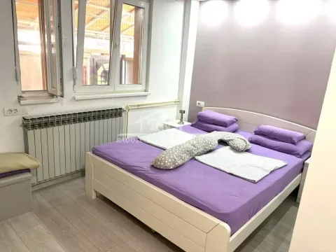 Furnished bedroom with a large double bed and windows. - image 9
