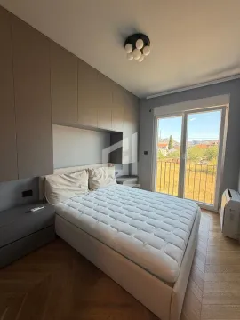 Modern bedroom with a double bed, built-in wardrobes, and balcony access. - image 6