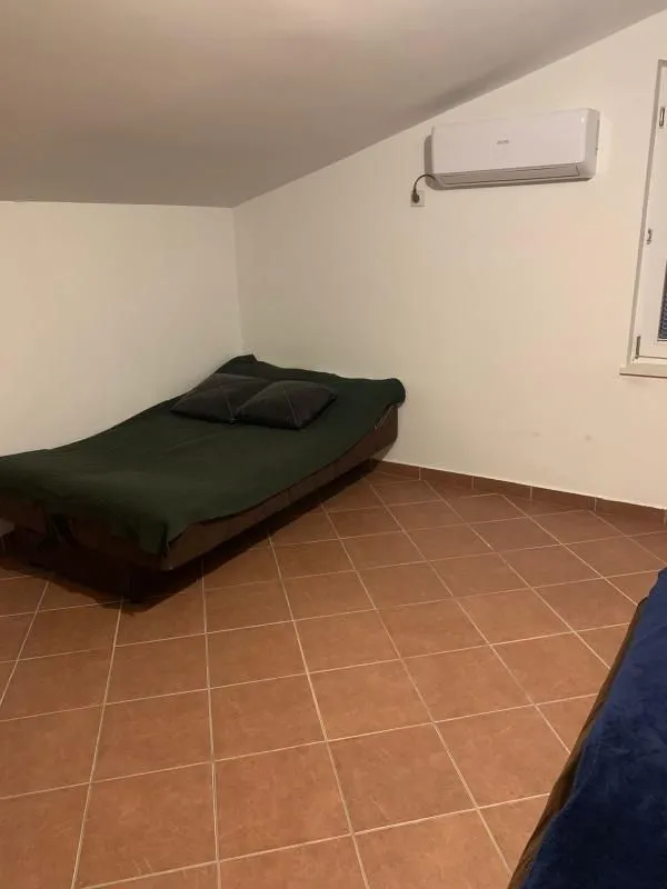 Smaller bedroom with a bed and an air conditioner.