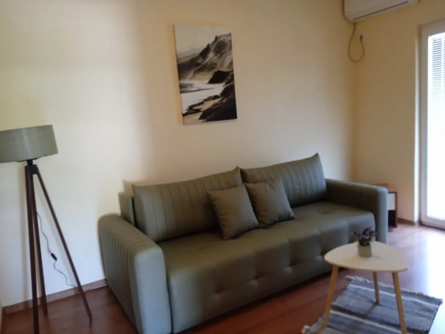 Living room with a green sofa, coffee table, and a lamp.