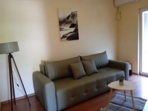 Living room with a green sofa, coffee table, and a lamp. - image 3