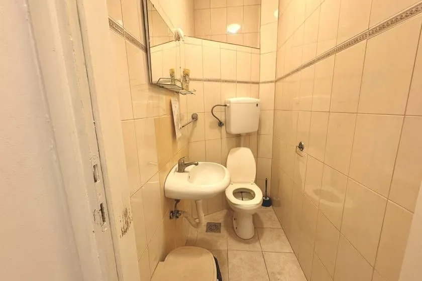Smaller tiled bathroom with a toilet and a washbasin.