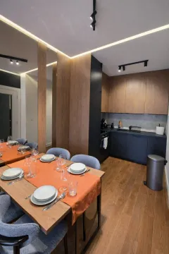 Modern kitchen with a dining table and built-in appliances. - image 2