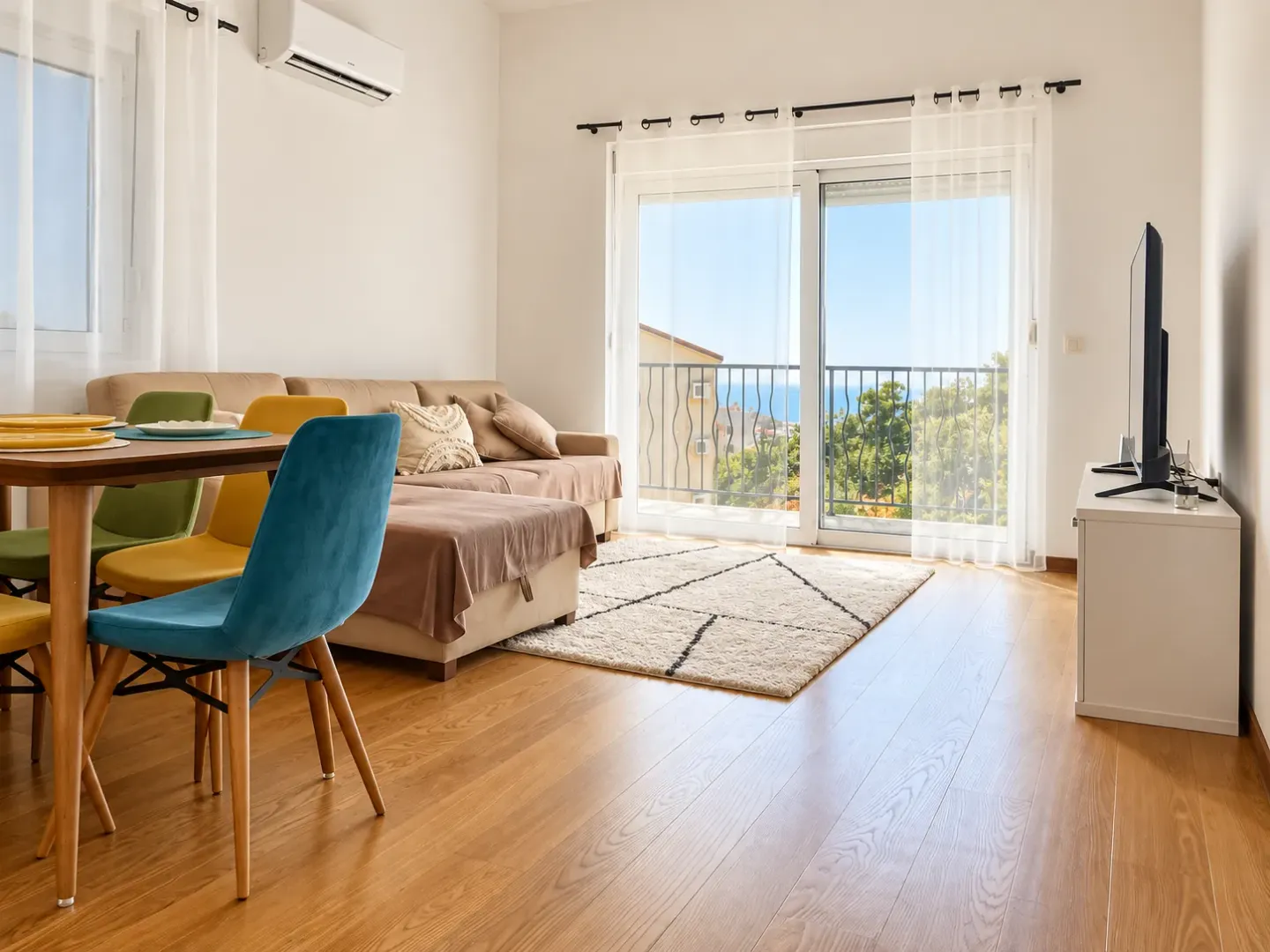 Bright living room with dining area and access to a terrace with a sea view.