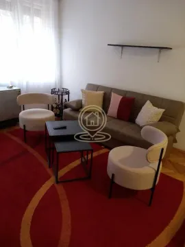 Dnevna soba sa garniturom, foteljama i stočićem na crvenom tepihu. - image 2