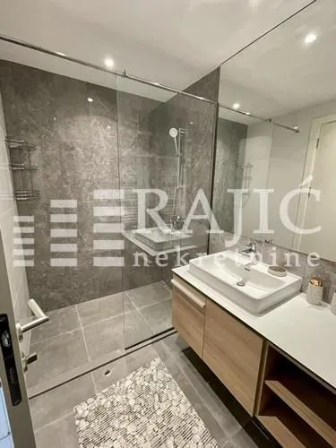 Modern bathroom with a walk-in shower and washbasin.