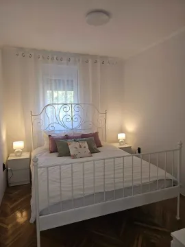 Spavaća soba sa bijelim metalnim krevetom i noćnim stočićima. - image 11