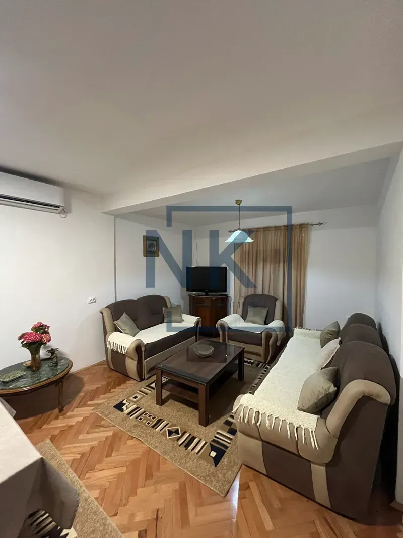 Living room with seating furniture, coffee table, and television.
