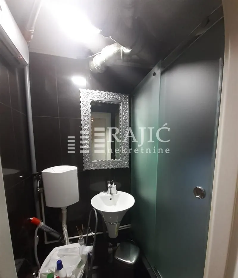 Small bathroom with a sink and shower enclosure.
