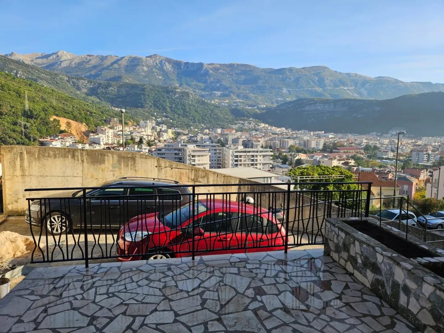 Pogled na grad i planine sa popločane terase ispred nekretnine.