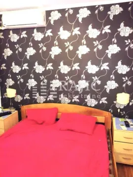 Furnished bedroom with a double bed and patterned wallpaper. - image 7