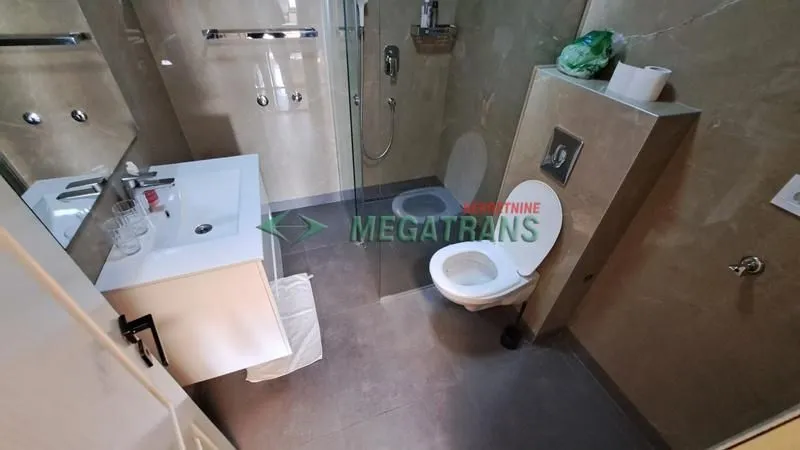Moderno opremljeno kupatilo sa tuš kabinom i umivaonikom.