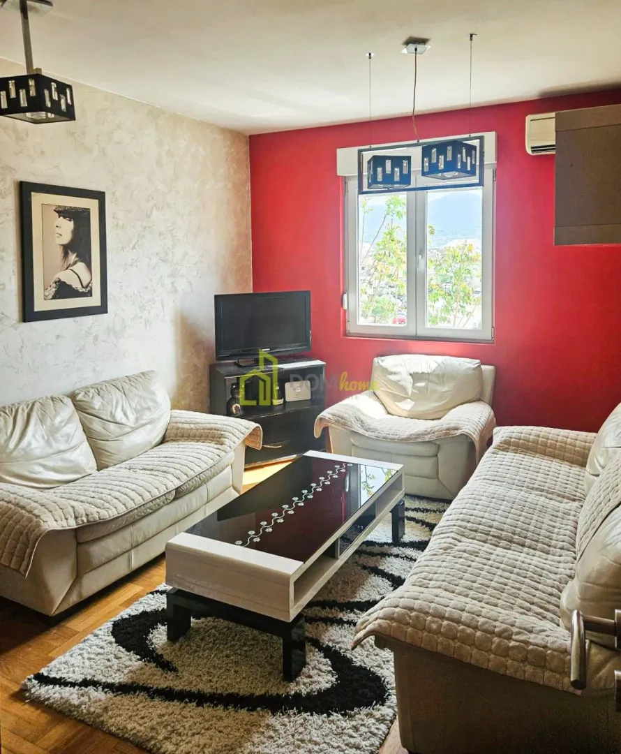 Living room with seating furniture, coffee table, and television.