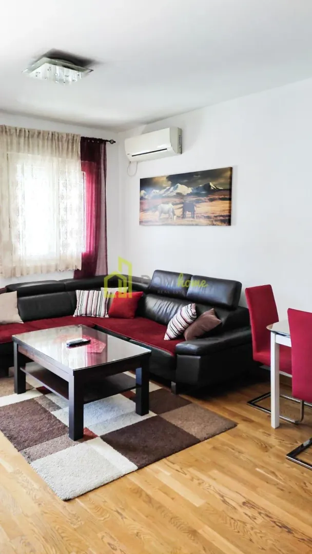 Living room with a sofa, coffee table, and dining table.