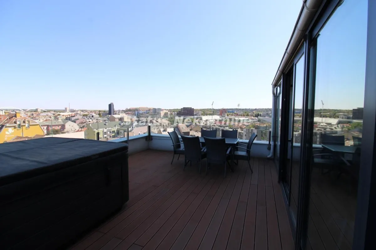 Spacious rooftop terrace with outdoor seating and a city view.
