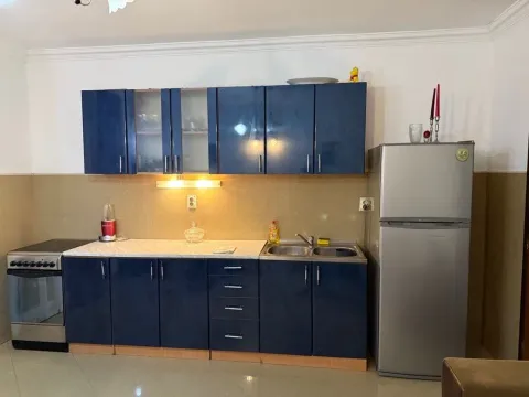 Kitchen with blue cabinets, stove, and refrigerator. - image 10