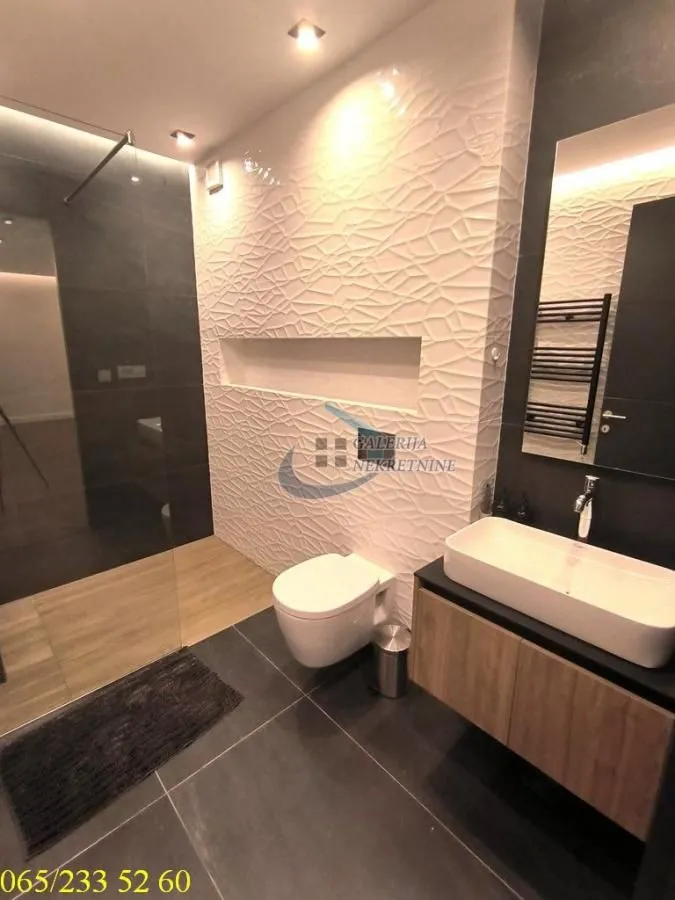 Savremeno opremljeno kupatilo sa tuš kabinom, umivaonikom i wc šoljom.