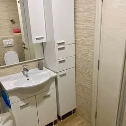 Bathroom equipped with a sink, cabinet, and toilet. - image 9