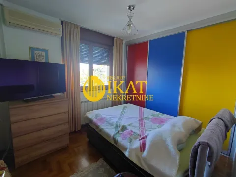 Spavaća soba sa krevetom, plakarom u boji i televizorom. - image 8