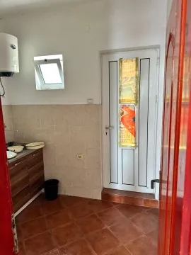 Small kitchen with a sink, cabinetry, and a white door. - image 6