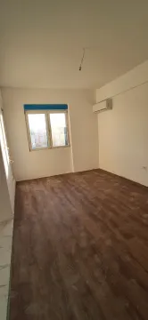 Prazna prostorija sa laminatnim podom i klima uređajem na zidu. - image 2