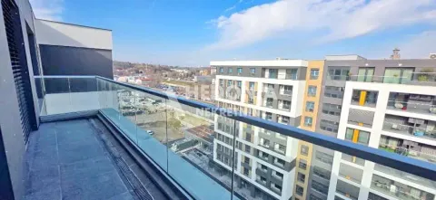 Moderan balkon sa staklenom ogradom i pogledom na okolne zgrade. - image 10