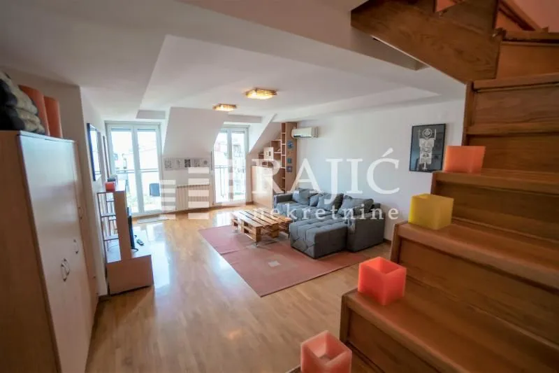 Living room with a sofa and wooden staircase.