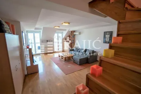 Living room with a sofa and wooden staircase. - image 8