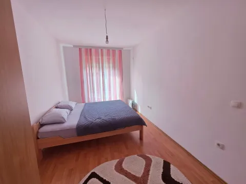 Empty bedroom with a double bed, wooden flooring, and a window with curtains. - image 3