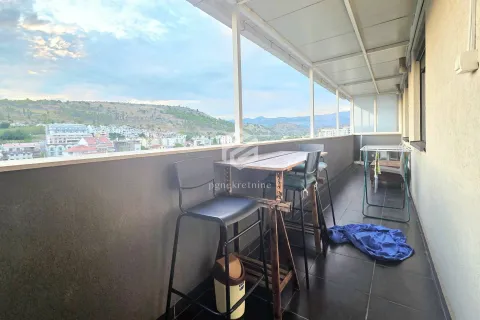 Covered terrace with a seating table and city view. - image 13