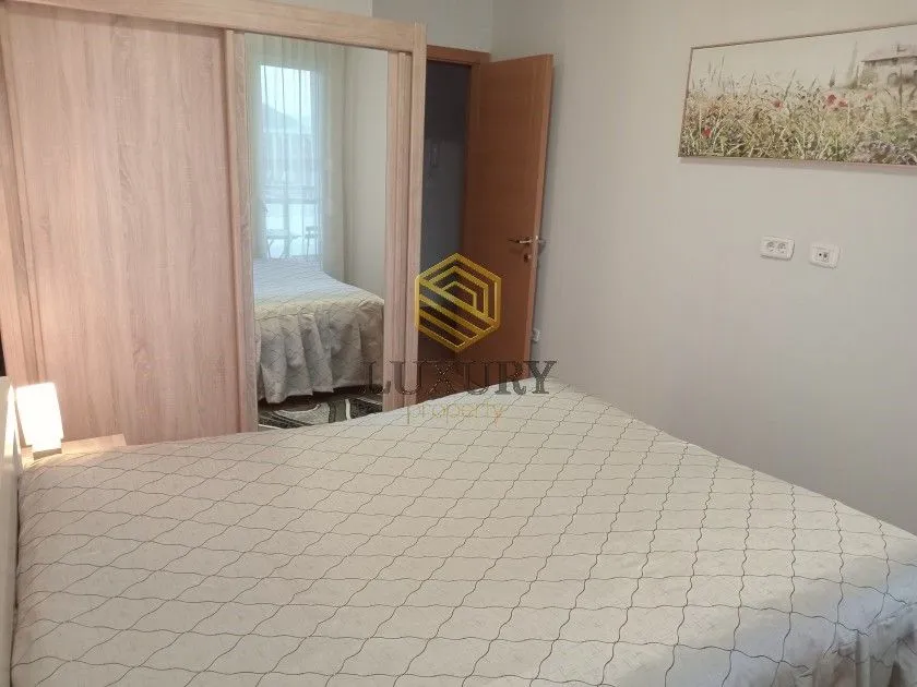Spavaća soba sa bračnim krevetom, velikim garderoberom i ogledalom.