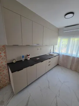 Moderna kuhinja sa bež elementima i tamnom radnom pločom. - image 6