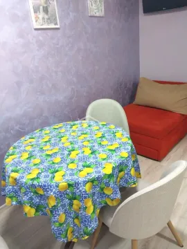 Trpezarijski sto sa stolicama i crveni kauč u sobi. - image 7
