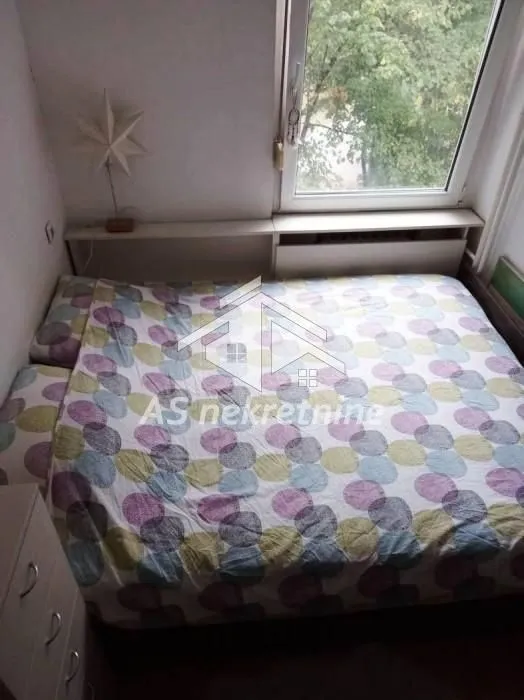 Smaller bedroom with a bed and a window.