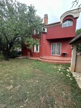 View of the yard and the rear facade of the house with a terrace and greenery. - image 3