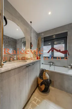 Moderno opremljeno kupatilo sa umivaonikom, velikim ogledalom i kadom. - image 19
